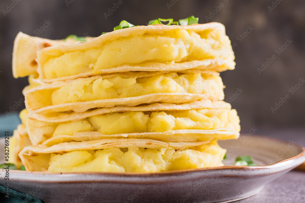 Close-up of Stacks of Kystyby - thin tortillas filled with mashed potatoes and onions on a plate. Close-up of Stacks of Kystyby - thin tortillas filled with mashed potatoes and onions on a plate.