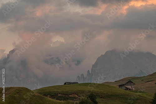 Wooden huts surrounded by the beautiful Dolomites mountains during the sunset