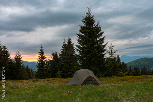  Tent on mountain col in grass in the morning. On background Mala Fatra mountains, Slovakia.