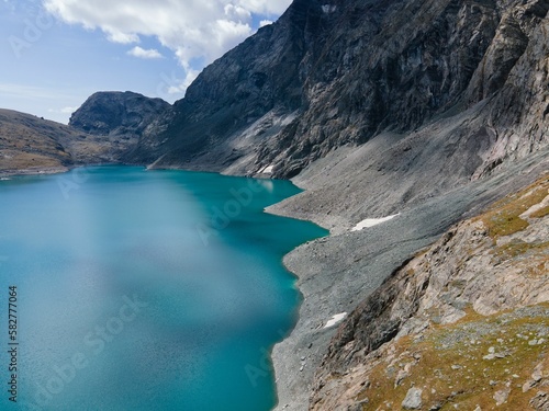 Aerial view of rocky mountains surrounded by lake in Usseglio