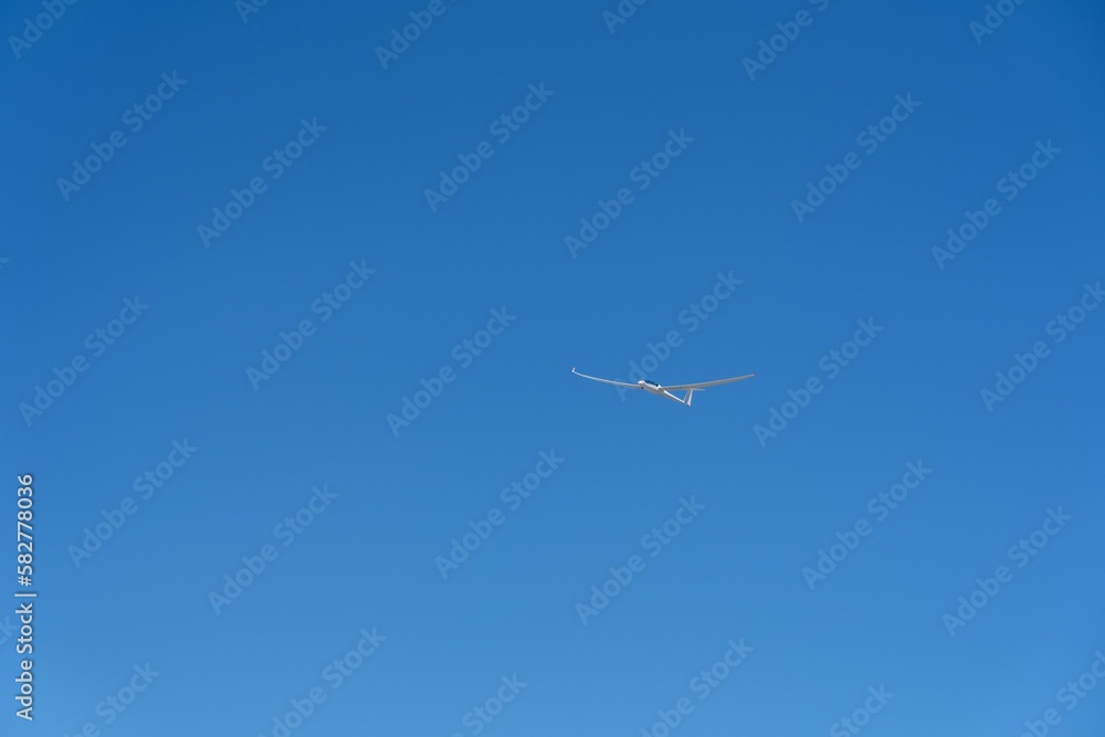 Scenic view of a glider over the mountains against the blue sky Scenic view of a glider over the mountains against the blue sky