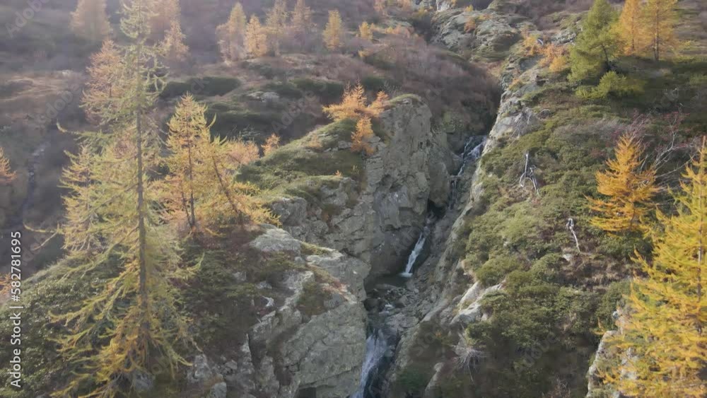 Aerial view of a Mountain valley with a waterfall and forest in autumn Aerial view of a Mountain valley with a waterfall and forest in autumn