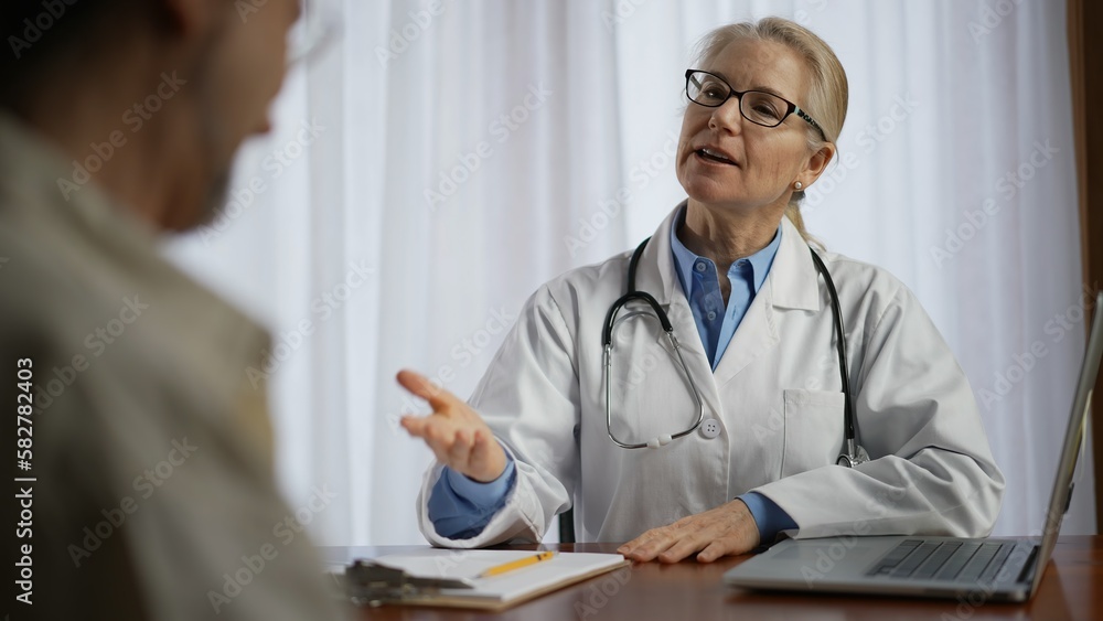 Fototapeta premium Female general practitioner sit at table in clinic office with aged patient talk about health test results, explain disease treatment prescriptions. Medical services for senior client concept