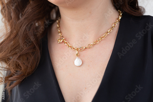 Close up attractive female model gold necklace and pearl pendant. Woman wearing jewellery. Jewellery photo for e commerce and online sale social media