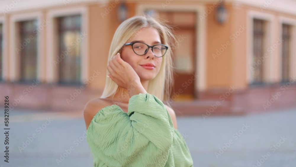 Close up face of beautiful blonde sexy smiling woman with long hair wearing glasses in stylish clothes. Portrait of a beautiful girl, looking at the camera, smiling and fixing her hair Close up face of beautiful blonde sexy smiling woman with long hair wearing glasses in stylish clothes. Portrait of a beautiful girl, looking at the camera, smiling and fixing her hair