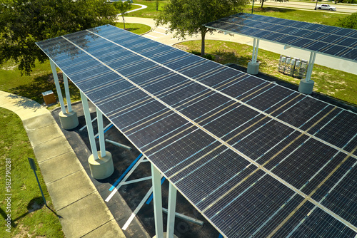 Aerial view of solar panels installed as shade roof over parking lot for parked cars for effective generation of clean electricity. Photovoltaic technology integrated in urban infrastructure
