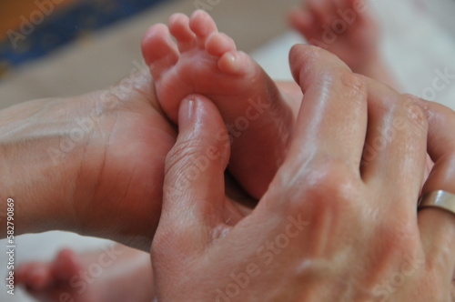 Baby foot reflexology massage with oil photo