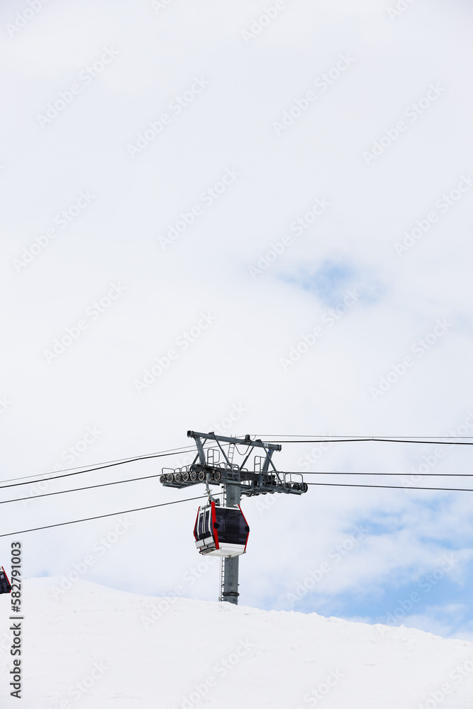 cable car are move on snowy mountain with skiers top view