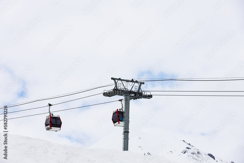 cable car are move on snowy mountain with skiers top view