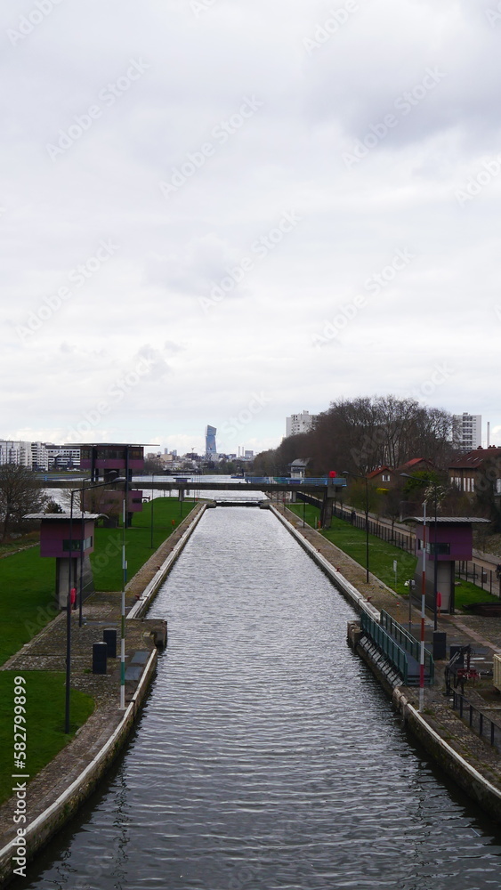 Ecluse pour changement de niveau d'eau pour transport maritime, contrôle industriel, sous un pont urbain et public, dans la Seine, passage obligatoire et contrôle de marchandise