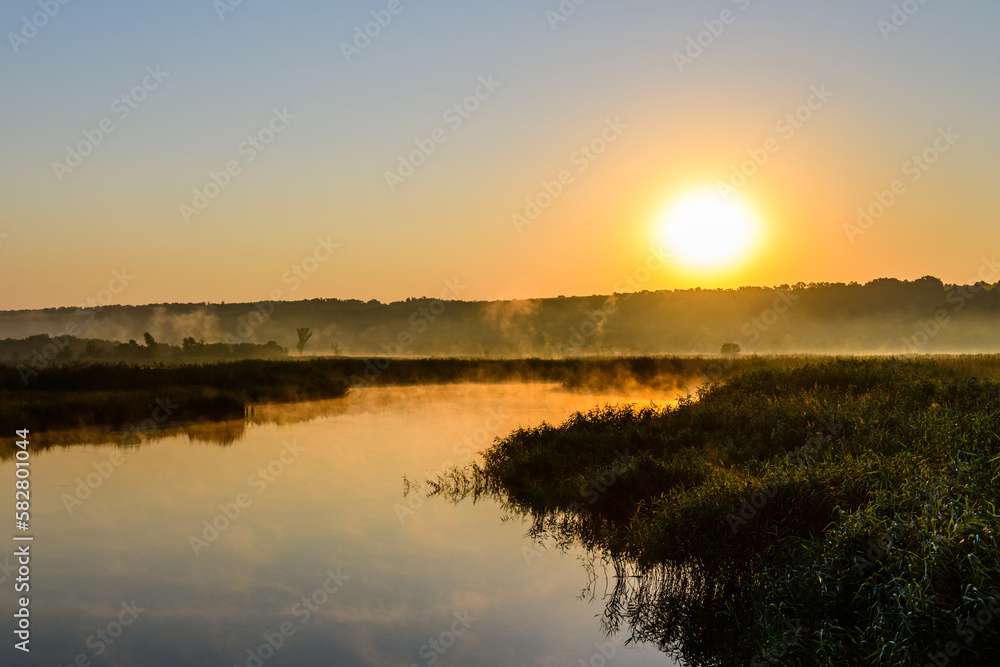 Fog above the water surface. Sunrise at river