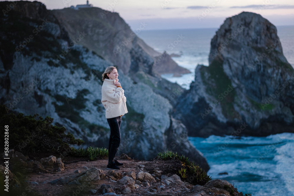Woman stands on the Atlantic cliffs near Cape Roca, Portugal. Woman stands on the Atlantic cliffs near Cape Roca, Portugal.
