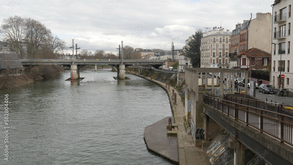 Promande au bord de la Seine, sous un ciel sombre et nuageux, et gris, atmosphère triste et lugubre, avec de la nature poussant de partout et sans limite, morte et triste, fleuve sale
