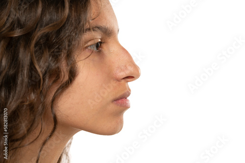 Photography Profile portrait of a beautiful serious young woman, a nose with a hump on white
