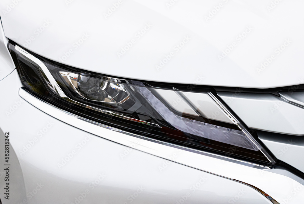 Detail light close up of on new white car. Exterior detail. Detail on one of the LED headlights super car.copy space