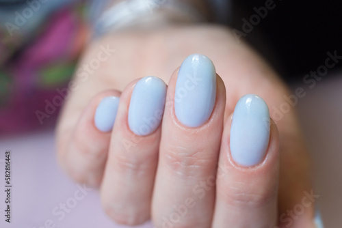 Women's hands with a blue nails. Nail design, manicure with gel polish 