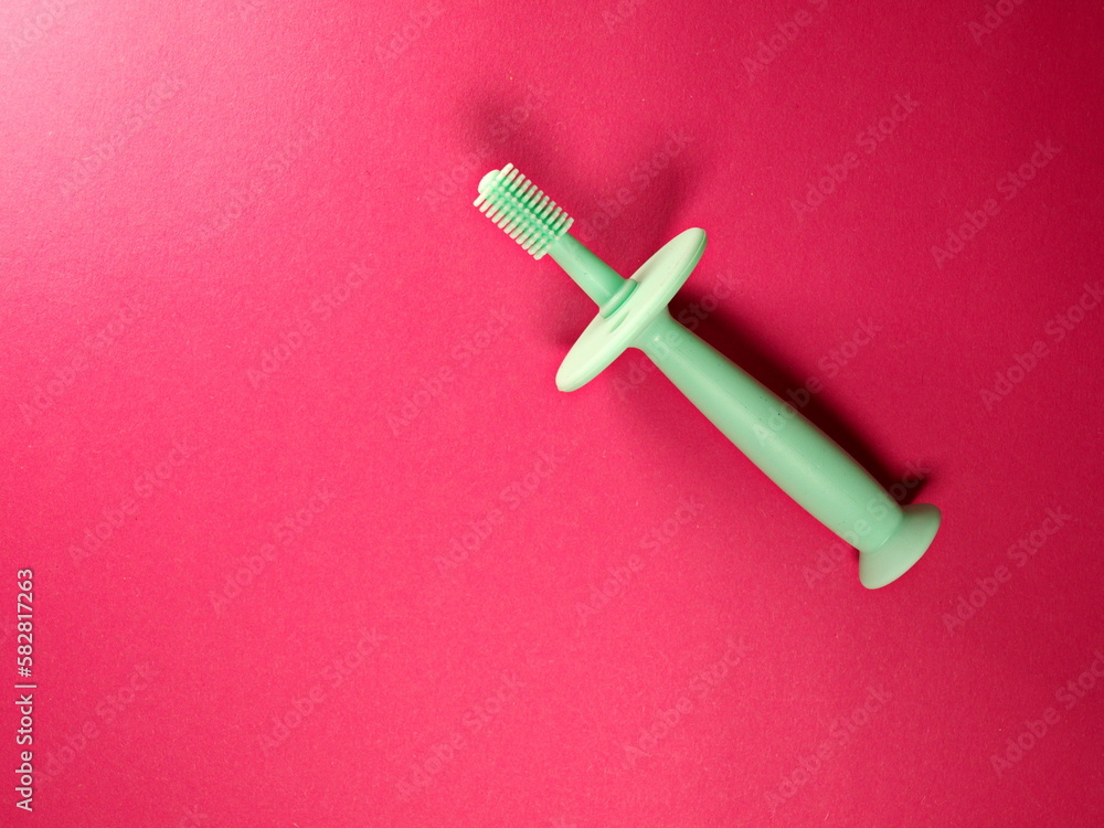 round silicone brush for milk teeth with a limiter on pink background with free space for text. Healthy Lifestyle. milk teeth and their care. oral care product. caries, caries prevention round silicone brush for milk teeth with a limiter on pink background with free space for text. Healthy Lifestyle. milk teeth and their care. oral care product. caries, caries prevention