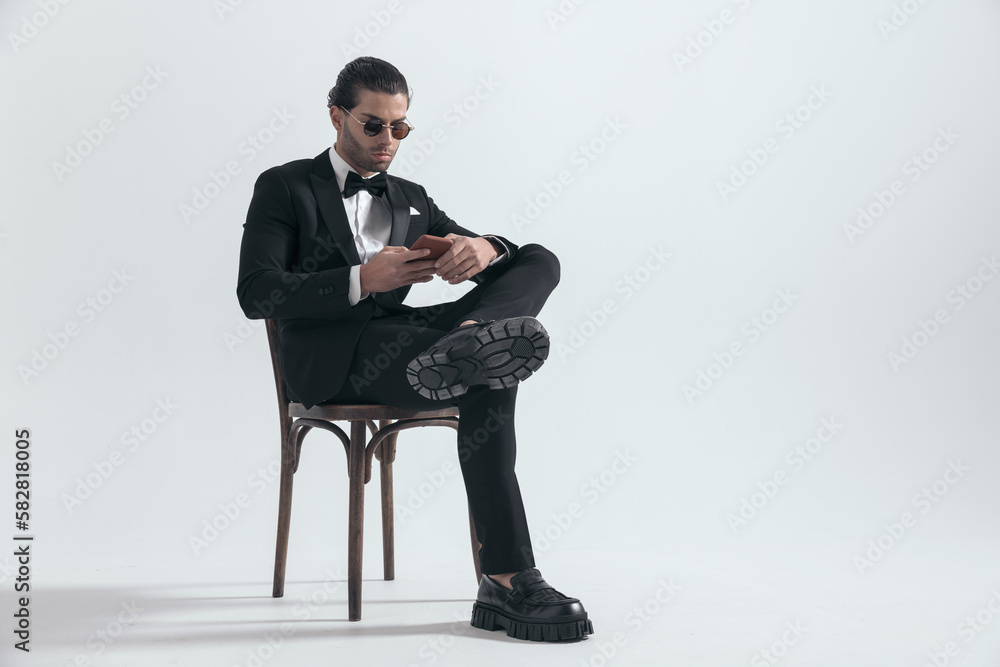 attractive elegant man with sunglasses scrolling on social media attractive elegant man with sunglasses scrolling on social media