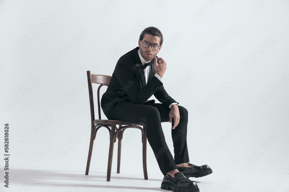 elegant young businessman with glasses sitting with elbows on thighs elegant young businessman with glasses sitting with elbows on thighs