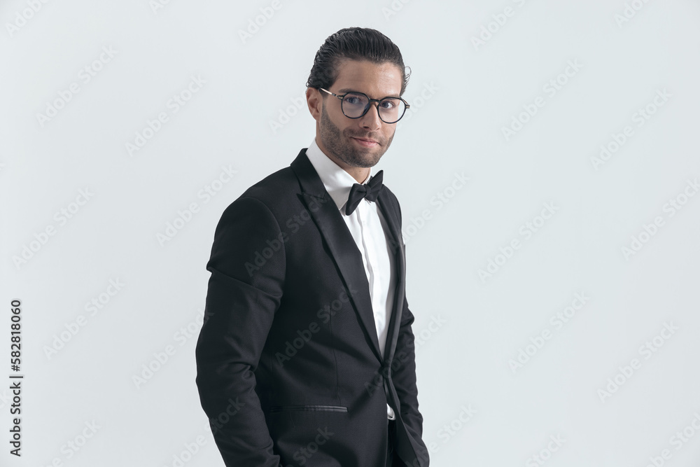 handsome elegant groom with glasses posing with hands in pockets handsome elegant groom with glasses posing with hands in pockets