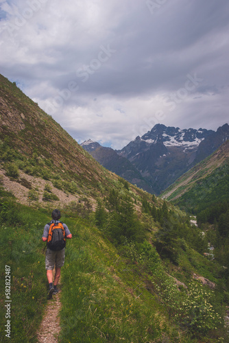 A male hiker walking in the Alps mountains in summer (Valgaudemar valley, Les Oulles du Diable hike)