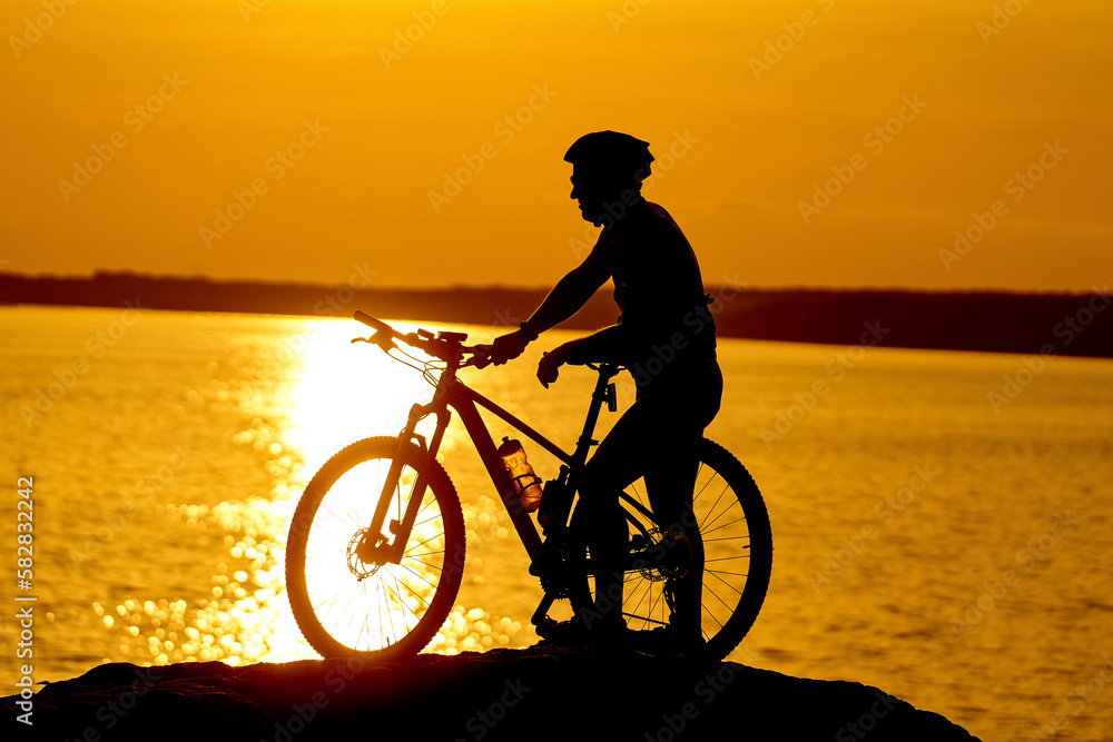 Fototapeta premium Silhouette biking summer ride. Sunset shadow of cyclist.