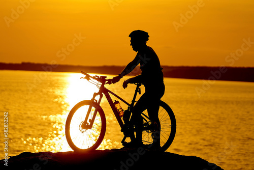 Silhouette biking summer ride. Sunset shadow of cyclist.