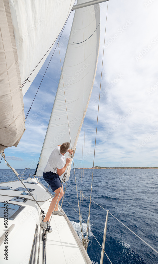 Fototapeta premium Man setting sail on his boat or yacht