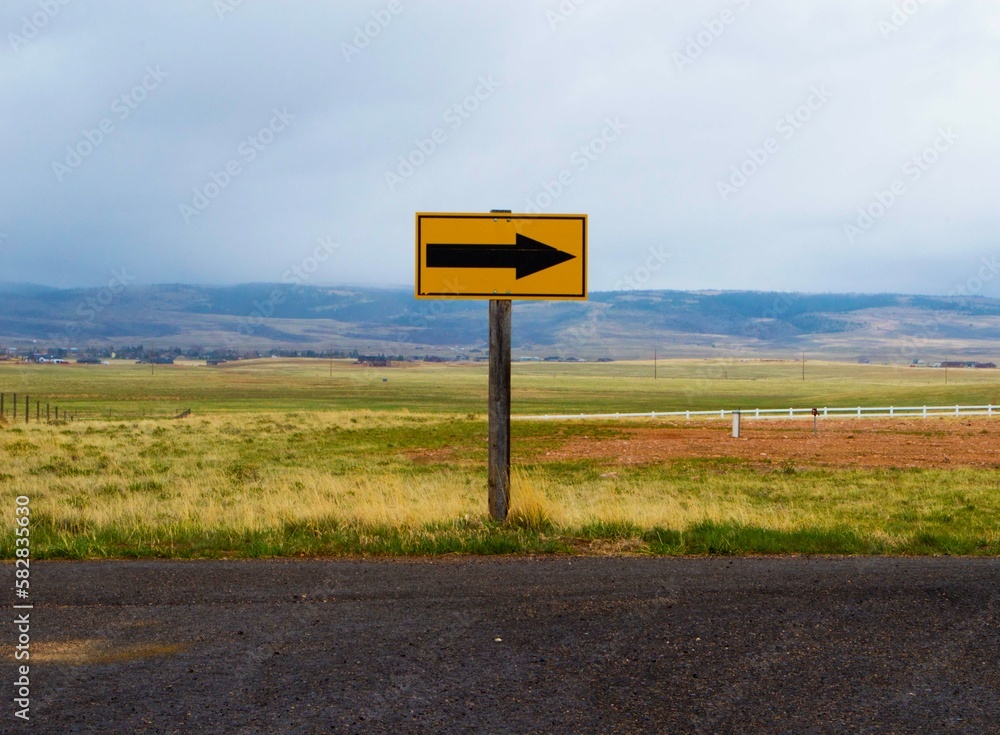 Road sign with arrow in countryside Road sign with arrow in countryside