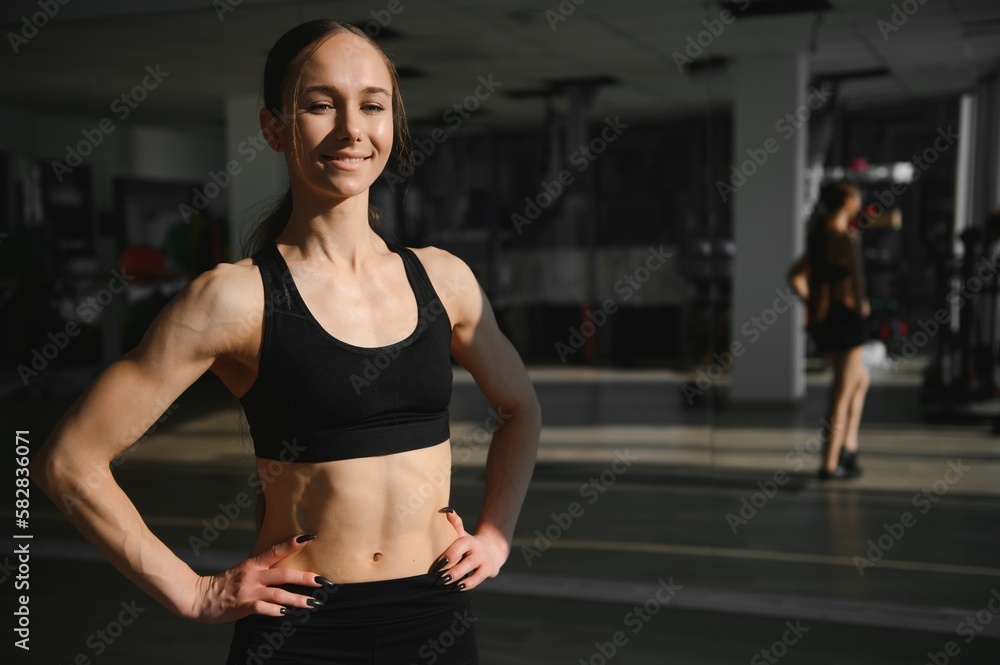 Brunette sexy fitness girl in sport wear with perfect body in the gym posing before training set Brunette sexy fitness girl in sport wear with perfect body in the gym posing before training set