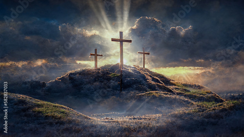 3 Crosses on a hill with sun rays and clouds in the background