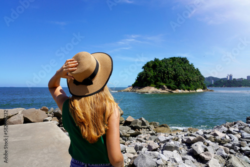 Traveler girl looking the uninhabited Urubuqueçaba Island near Santos coast, Baixada Santista, Brazil photo