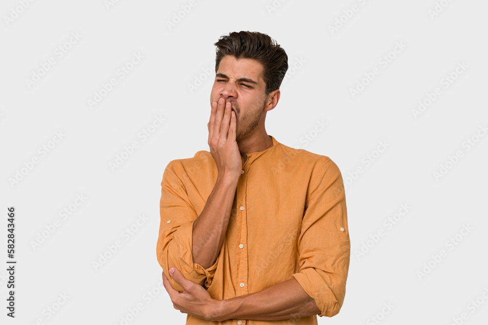 Young handsome caucasian man isolated on white background yawning showing a tired gesture covering mouth with hand. Young handsome caucasian man isolated on white background yawning showing a tired gesture covering mouth with hand.