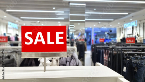 The sale inscription is on a red sign in the store. focus on the inscription. 