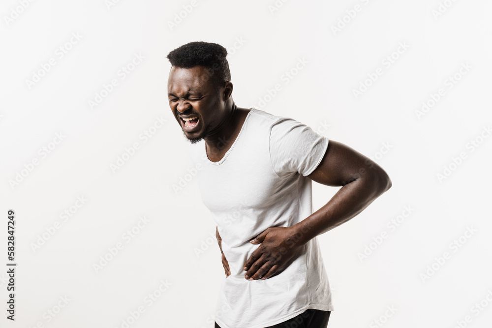 Ulcer or gastritis stomach ache. Sick african american man hold abdomen because it hurts. Pancreatitis disease of pancreas becomes inflamed. Ulcer or gastritis stomach ache. Sick african american man hold abdomen because it hurts. Pancreatitis disease of pancreas becomes inflamed.