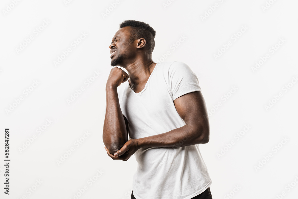 Elbow injury causing pain, swelling, stiffness, and limited movement. Fractures, dislocations, sprains, and tennis elbow. Elbow injury of african american man isolated on white background. Elbow injury causing pain, swelling, stiffness, and limited movement. Fractures, dislocations, sprains, and tennis elbow. Elbow injury of african american man isolated on white background.