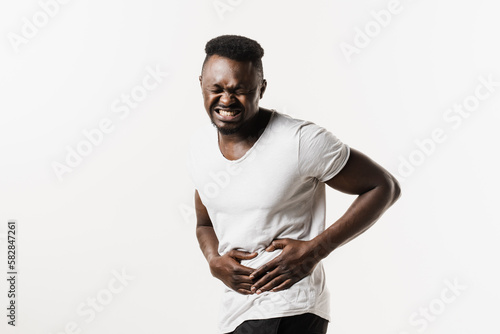Stomach pain. Pancreatitis disease of pancreas becomes inflamed. Sick african american man hold abdomen because it hurts.