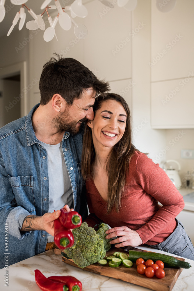 Young man spending some quality time with his beautiful wife, while making lunch together. Young man spending some quality time with his beautiful wife, while making lunch together.
