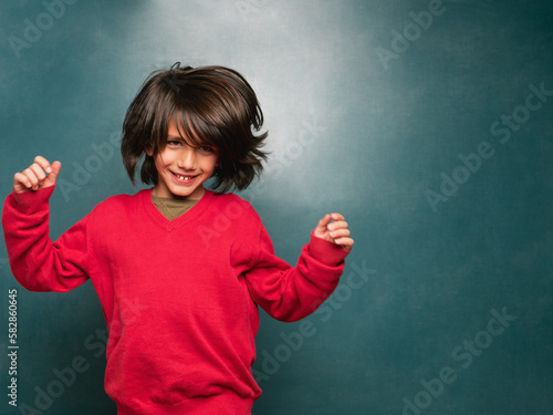 Boy in a red sweater dancing to the rhythm of the music