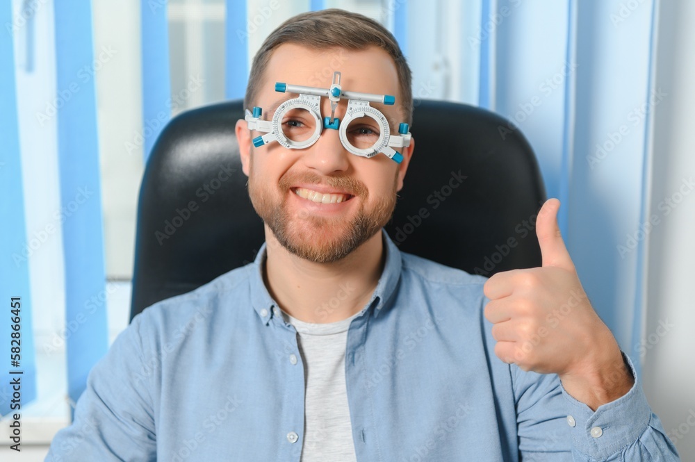 Handsome young man is checking the eye vision in modern ophthalmology clinic. Patient in ophthalmology clinic Handsome young man is checking the eye vision in modern ophthalmology clinic. Patient in ophthalmology clinic