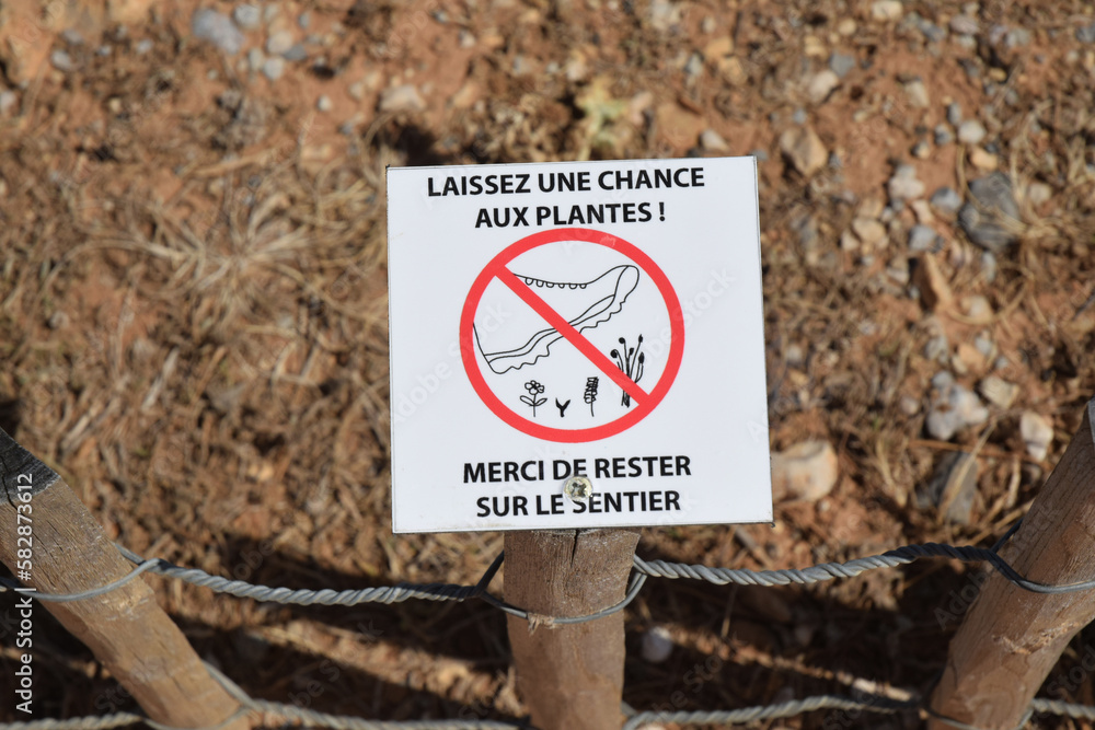 Panneau : laissez une chance aux plantes, merci de rester sur le sentier. Panneau : laissez une chance aux plantes, merci de rester sur le sentier.