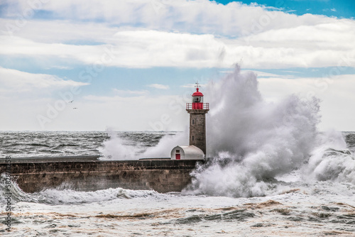 Waves crashing on lighthouse on the beach. Farolim de Felgueiras  Porto  Portugal