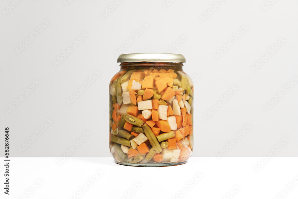 A large glass jar with a canned vegetable stew A large glass jar with a canned vegetable stew