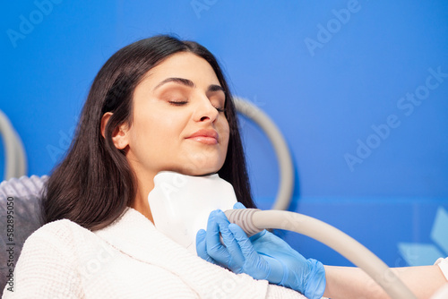 coolsculpting procedure in cosmetology clinic, cosmetologist doctor makes procedure for removing fat from the chin photo