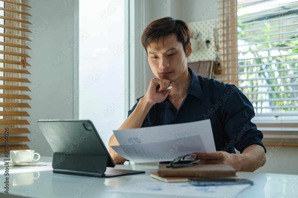 Concentrated man accountant working with satistic document at bright workplace. Concentrated man accountant working with satistic document at bright workplace.
