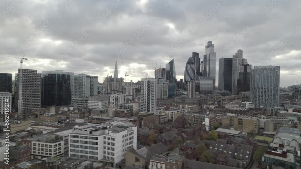 Iconic skyscrapers in business hub against cloudy sky. Fly above town development in residential borough. London, UK Iconic skyscrapers in business hub against cloudy sky. Fly above town development in residential borough. London, UK
