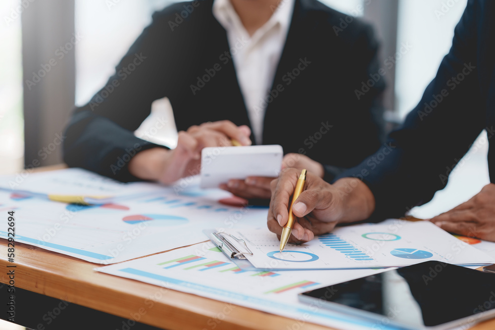 Business team meeting and using calculator to calculate statistical growth rate of business on document graph data. Business team meeting and using calculator to calculate statistical growth rate of business on document graph data.