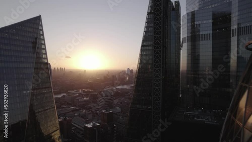  Picturesque sunset above large city. Backwards reveal of futuristic high rise skyscrapers. London, UK