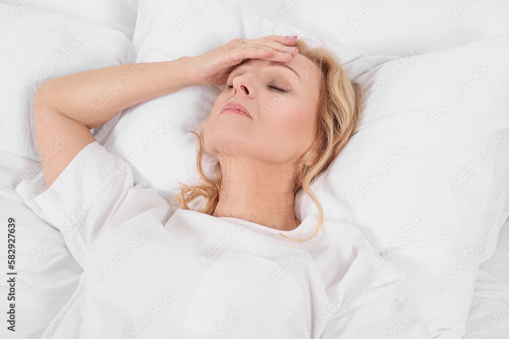 Woman suffering from headache in bed. Hormonal disorders