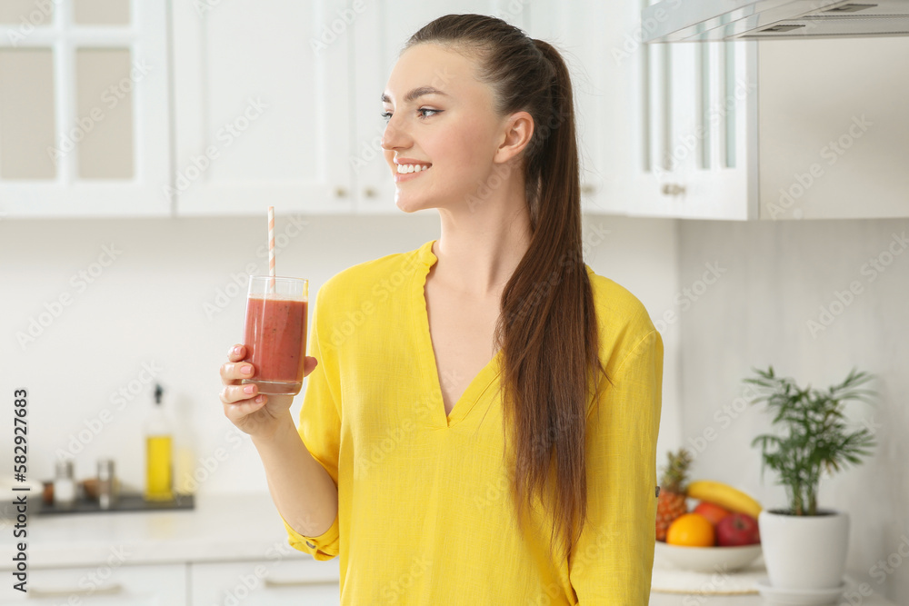 Beautiful young woman with delicious smoothie in kitchen Beautiful young woman with delicious smoothie in kitchen